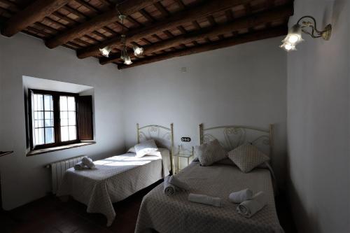 a bedroom with two beds and a window at Villa Escutia in Cazalla de la Sierra