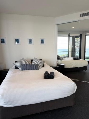 a bedroom with two beds and a large mirror at Newcastle Beach Escape in Newcastle
