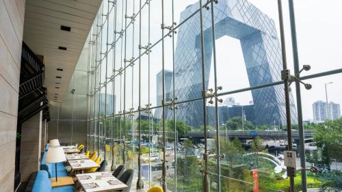 a restaurant with a view of a city through a glass wall at JEN Beijing by Shangri-La in Beijing