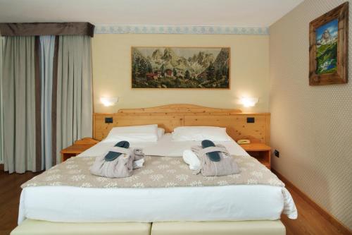 a bedroom with a large bed with towels on it at Hotel Edelweiss 3 Stelle SUPERIOR in Breuil-Cervinia