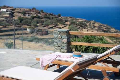 a person sitting on a bed with a hat on it at Taeri Sifnos in Sifnos