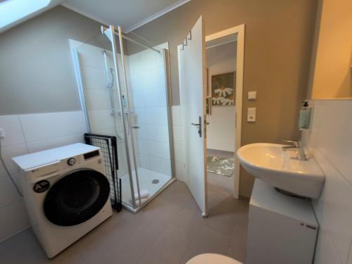a bathroom with a shower and a washing machine at Gut Vorbeck in Gneven