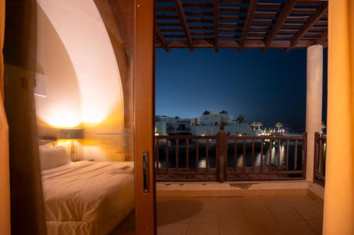 a room with a bed and a balcony with a view at 2 Bedroom Villa with Private Pool in Ras al Khaimah