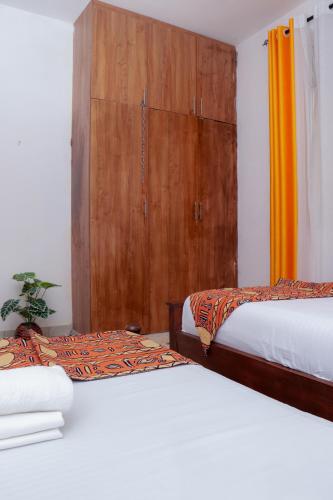 a bedroom with two beds and a wooden door at Bamburi BnB in Mombasa