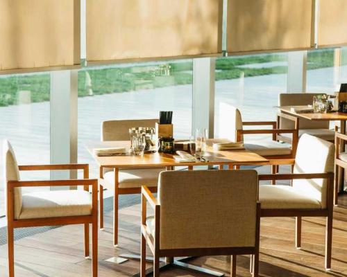 a restaurant with wooden tables and chairs and a large window at Hyatt Regency Beijing Wangjing in Beijing
