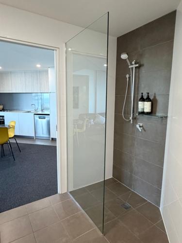a bathroom with a shower with a glass door at Newcastle Beach Escape in Newcastle