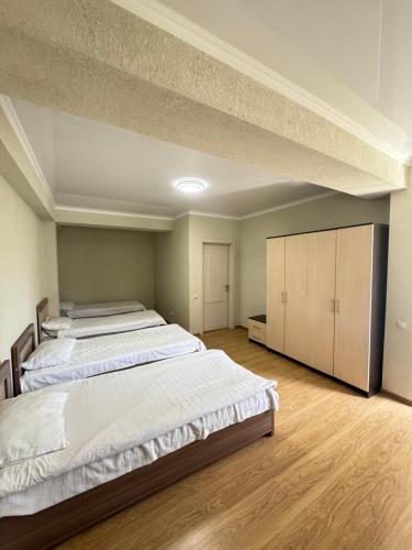 a large bedroom with two beds and wooden floors at HOTEL Vzmorye in Bosteri