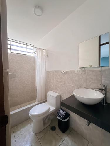 a bathroom with a white toilet and a sink at Dream Place Trujillo in Trujillo