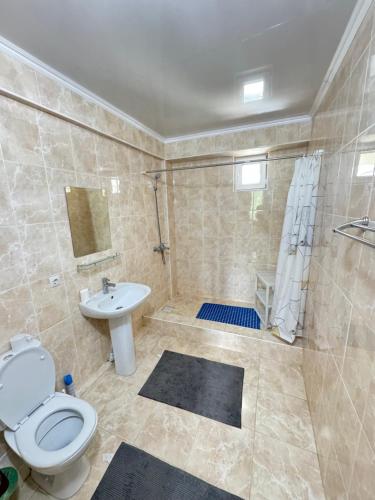 a bathroom with a toilet and a shower and a sink at HOTEL Vzmorye in Bosteri