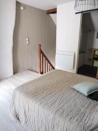 a large bed in a room with a staircase at La maison d'André in Laurière