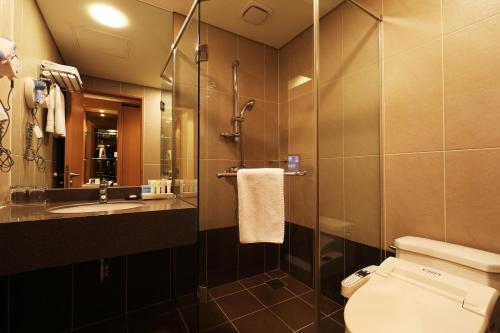 a bathroom with a shower and a toilet and a sink at Bridge Hotel Incheon Songdo in Incheon