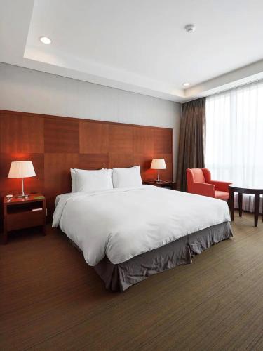 a large white bed in a hotel room at Bridge Hotel Incheon Songdo in Incheon