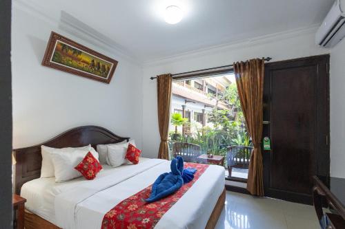 a bedroom with a bed and a window at Taman Ayu Legian Hotel in Legian