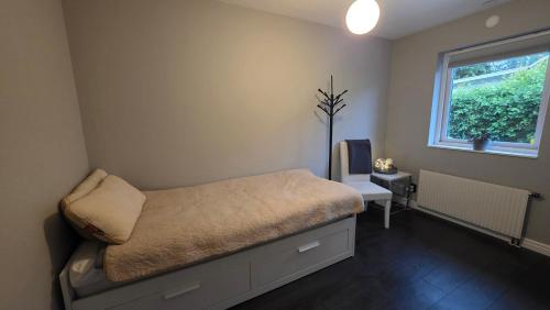 a small bedroom with a bed and a window at Modern cosy house with forest views in Södertälje