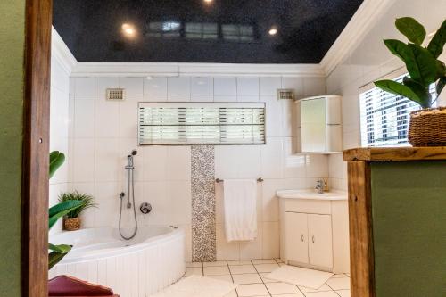 a white bathroom with a tub and a sink at Gillys Accommodation in Camperdown
