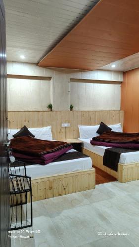 two beds in a large room with at Jai Shri Badri in Badrinath