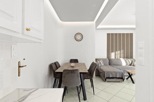 a dining room with a table and chairs and a couch at Minimal Stay House in Petalidi
