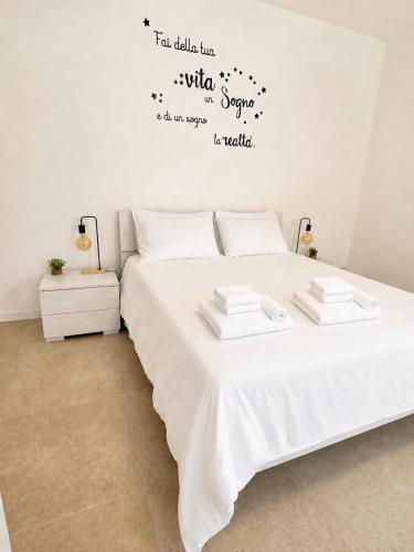 a bedroom with a white bed with words on the wall at Appartamento Sofia in Sossano