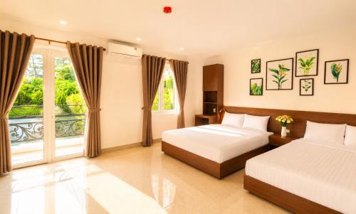a bedroom with two beds and a large window at Lien's 2 Hotel Dalat in Da Lat