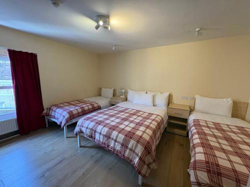 a hotel room with two beds and a window at Seven Dials Hotel in London