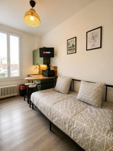 a bedroom with a bed and a desk in it at Les Sources Vichy in Vichy