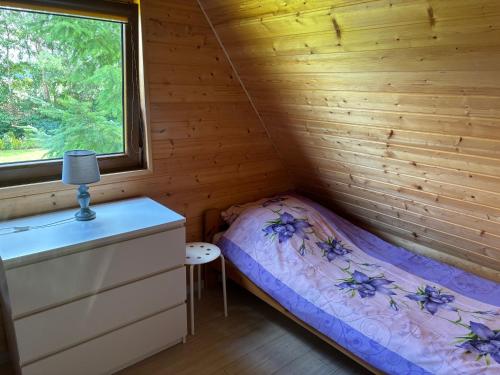 a small bedroom with a bed and a window at Agroturystyka i Domki Zacisze in Jarosławiec