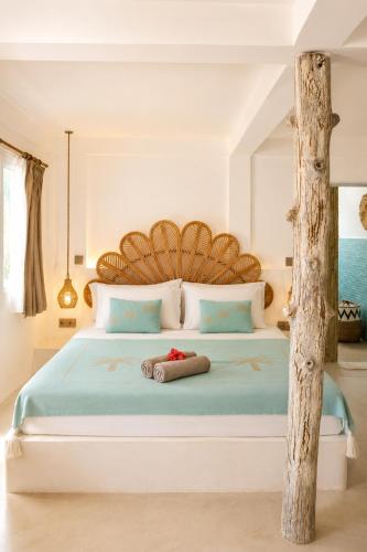 a bedroom with a large bed with a wooden headboard at Villa Norte in Gili Islands