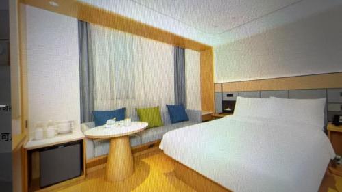 a bedroom with a bed and a sink and a window at JI Hotel Beijing Huilongguan in Changping
