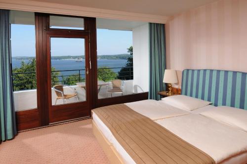 a hotel room with a bed and a balcony at Maritim Hotel Bellevue Kiel in Kiel