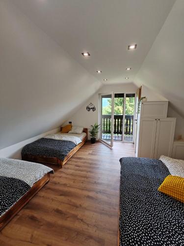 a room with three beds and a large window at Chalet Zasavka in Dol pri Hrastniku