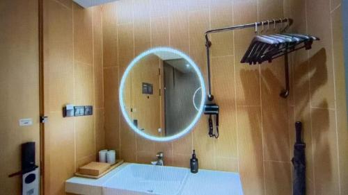 a bathroom with a round mirror and a tub at JI Hotel Beijing Huilongguan in Changping