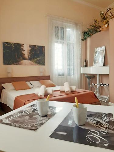a bedroom with two beds and a table with cups at *1*7*4* Via Roma in Palermo