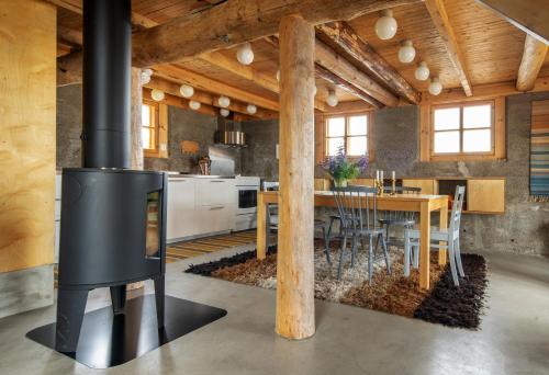 a kitchen and dining room with a wood stove at Villa Lofoten - The Saltery in Kvalnes