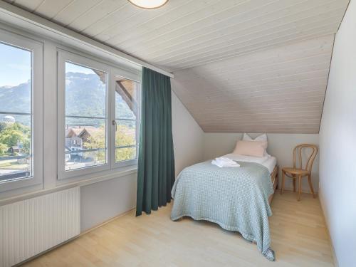 a small bedroom with a bed and a window at Mohn in Interlaken