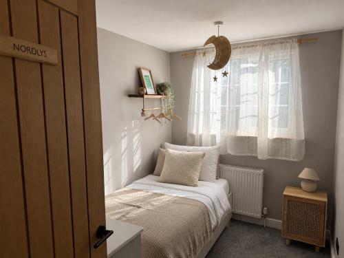 a small bedroom with a bed and a window at Nordic Spa House in Brandon
