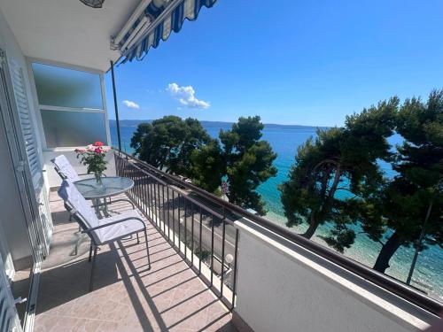 a balcony with a table and chairs and the ocean at Apartment Verica in Krilo
