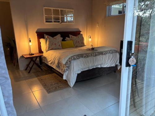 a bedroom with a bed in a room with a window at Dune Ridge Cottage in Port Alfred