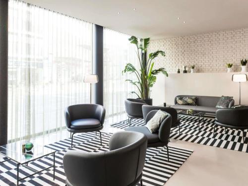 a lobby with couches and chairs in a building at ibis Brussels Centre Chatelain in Brussels