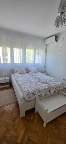 a bedroom with a large bed with a floral bedspread at Apartman Lavanda in Vrdnik