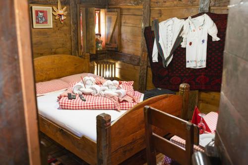 a small bedroom with two dolls laying on a bed at Brvnara Jez in Kraljevo