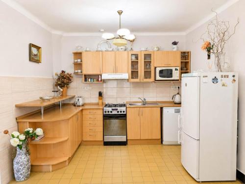 a kitchen with wooden cabinets and a white refrigerator at Astronomical Clock Apartment in Prague