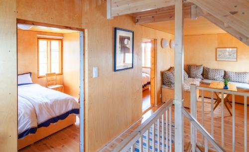 a bedroom with a bed and a staircase in a room at Villa Lofoten - The Saltery in Kvalnes