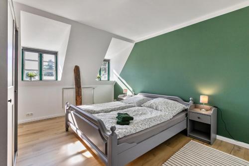 a bedroom with a bed with a green wall at Historischer Resthof in Hövede