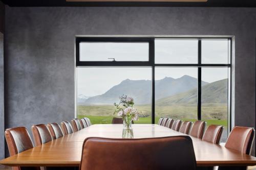 a dining room with a table and chairs and a large window at Tindasel - The Farm in Hella
