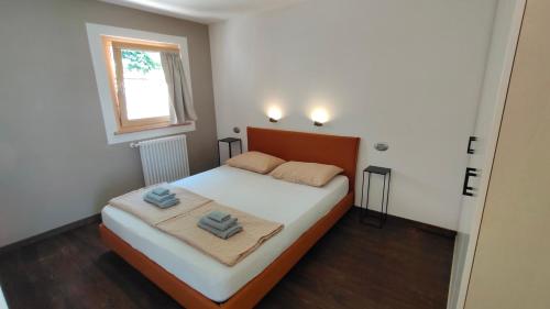 a bedroom with a bed with two towels on it at Chalet al Lac - Cuori - Swimming Pool Como Lake View in Consiglio di Rumo