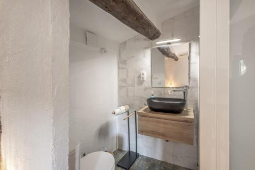 a bathroom with a black sink and a toilet at Eco Masias Cal Ferran in El Bruc