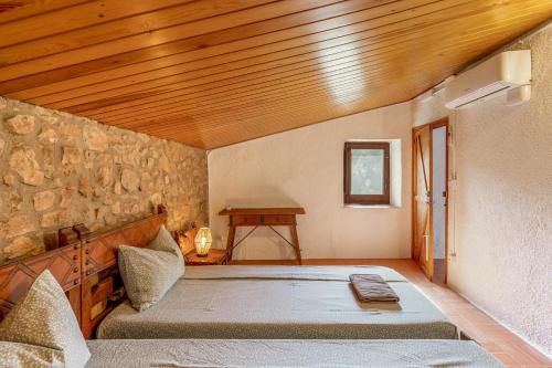 a bedroom with a large bed with a wooden ceiling at Eco Masias Cal Ferran in El Bruc