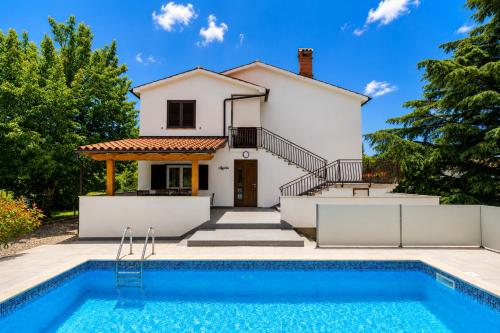 a villa with a swimming pool in front of a house at Magnolia by Briskva in Vinež
