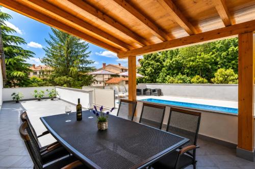 a patio with a table and chairs and a swimming pool at Magnolia by Briskva in Vinež