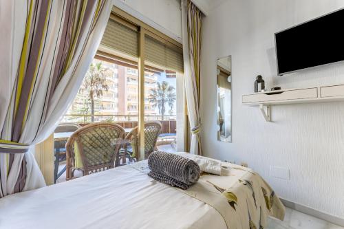 a bedroom with a bed and a tv and a balcony at Doña Sofía in Fuengirola